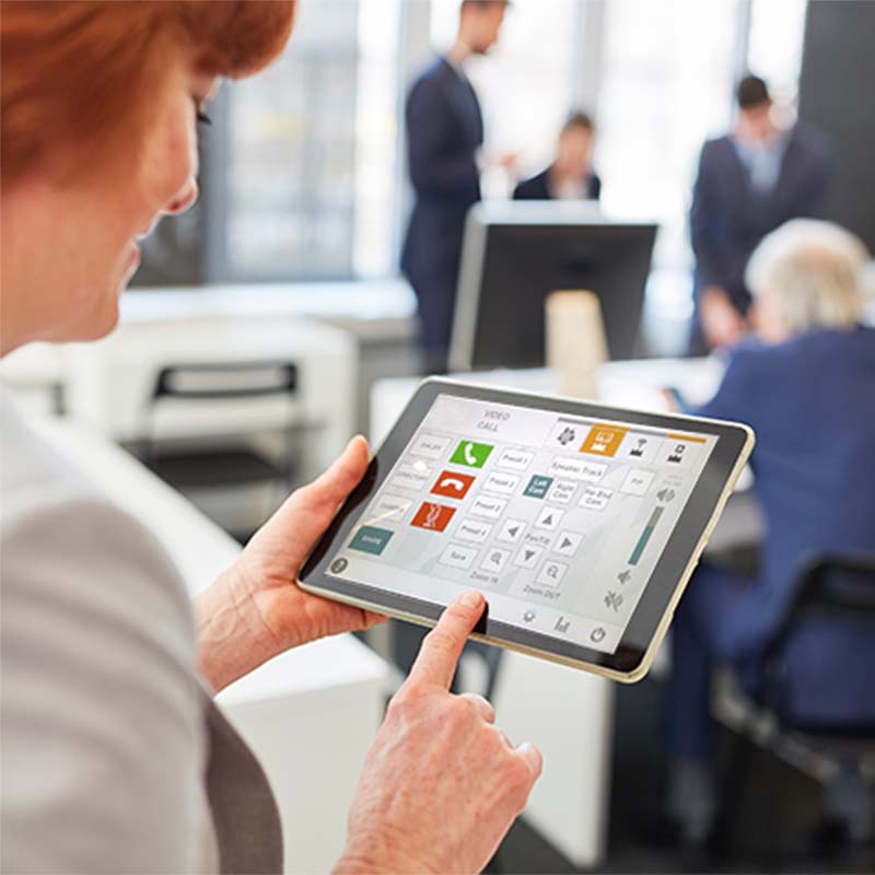 Woman using tablet to control meeting settings